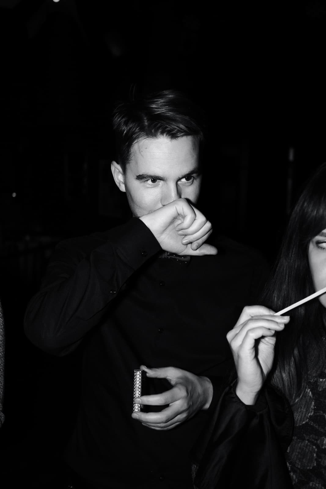 A guest smelling perfume from the back of his hand at a club evening
