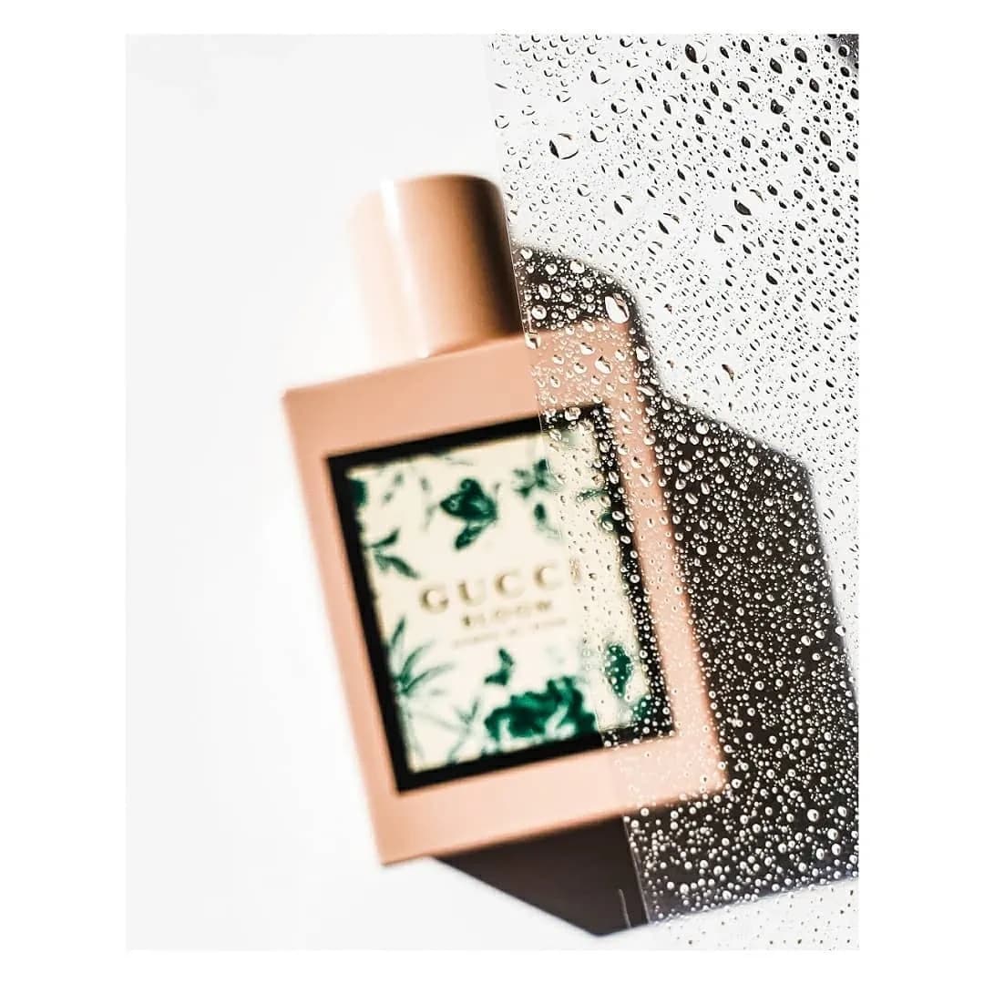 Blush bottle behind a pane of glass covered in water droplets