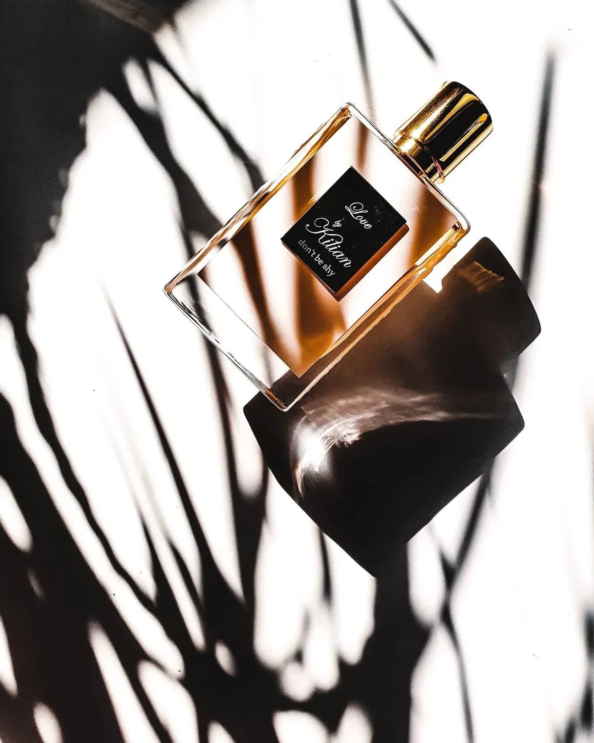 A niche perfume bottle styled with flowers and props for a studio product shot